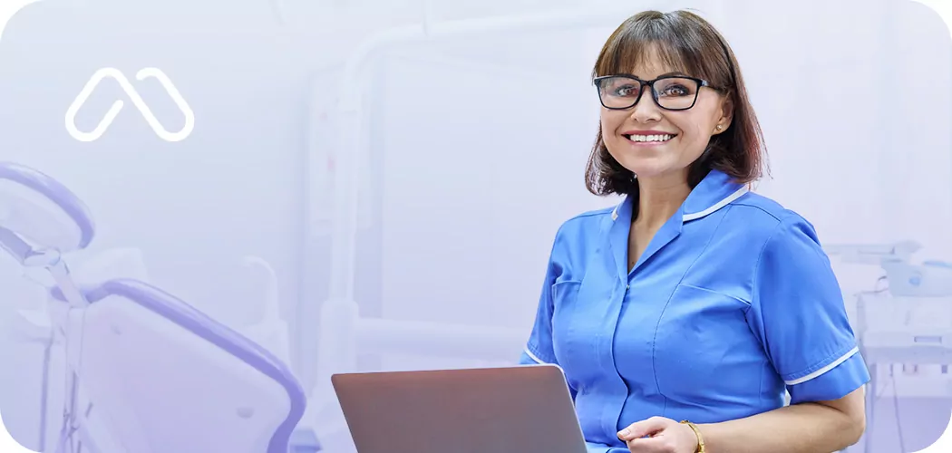 nurse with a laptop smiling at the camera