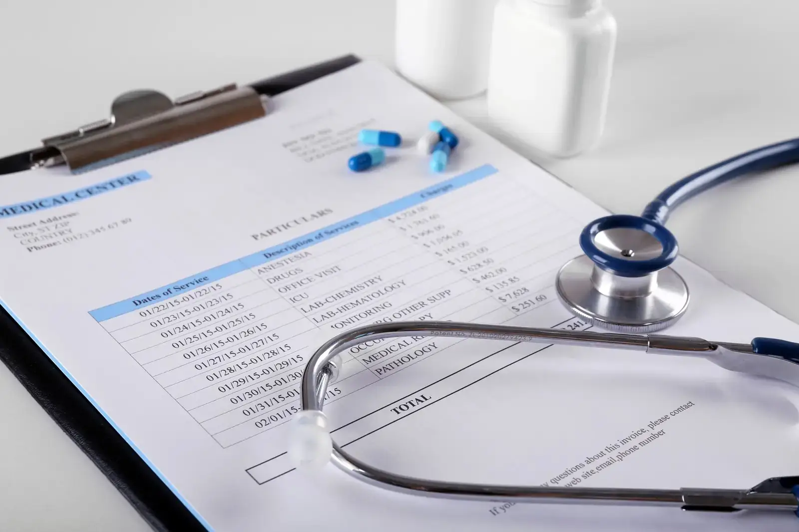Itemized medical invoice on a clipboard beside a stethoscope